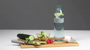 Mepal Flasche mit ENTDECKE DEIN NEO-Logo steht auf einem Schneidebrett, daneben Obst und Gemüse.