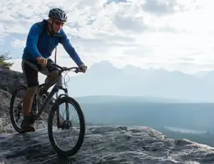 Mann fährt Fahrrad auf Berg.