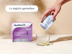 Medibiotix Gluco Packung neben einem Glas, in das der Inhalt des Sachtes ausgeleert wird.