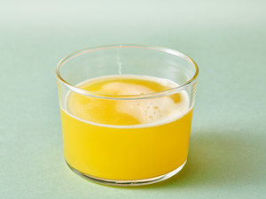 Glas mit gelber Flüssigkeit.