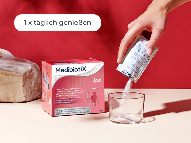 Medibiotix Lipo Packung neben einem Glas, in das der Inhalt des Sachtes ausgeleert wird