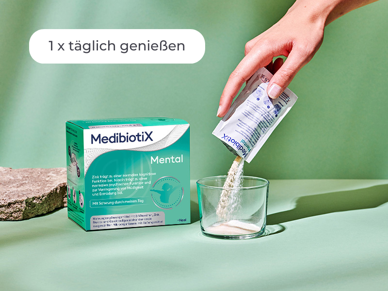 Medibiotix Mental Packung neben einem Glas, in das der Inhalt des Sachtes ausgeleert wird.
