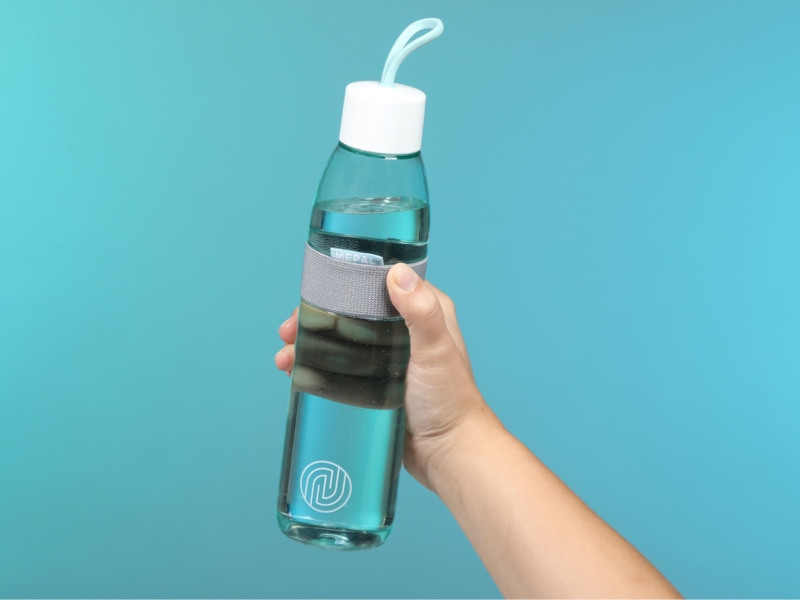 Mepal Flasche mit ENTDECKE DEIN NEO-Logo wird in einer Hand gehalten
