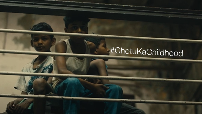 Three children behind bars with the #chotukachildhood