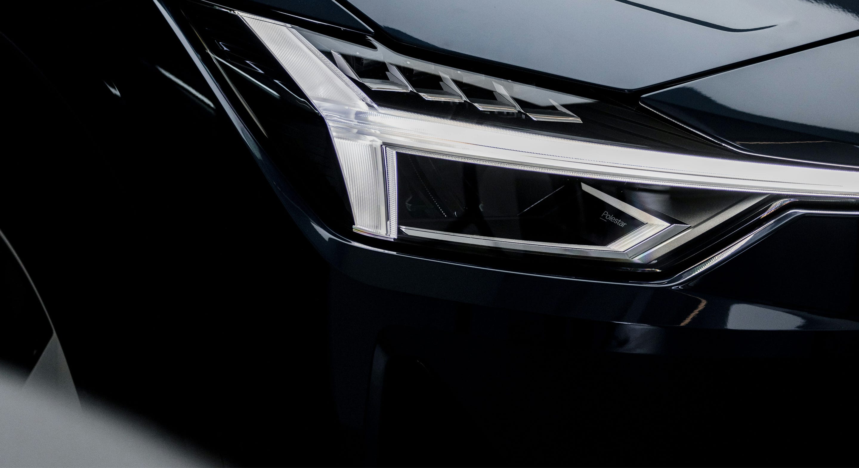 The front of a car focussing on the headlight and bumper