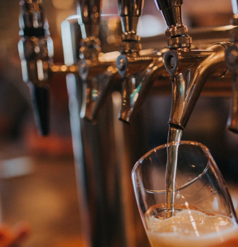 A pint of beer being poured from the bar