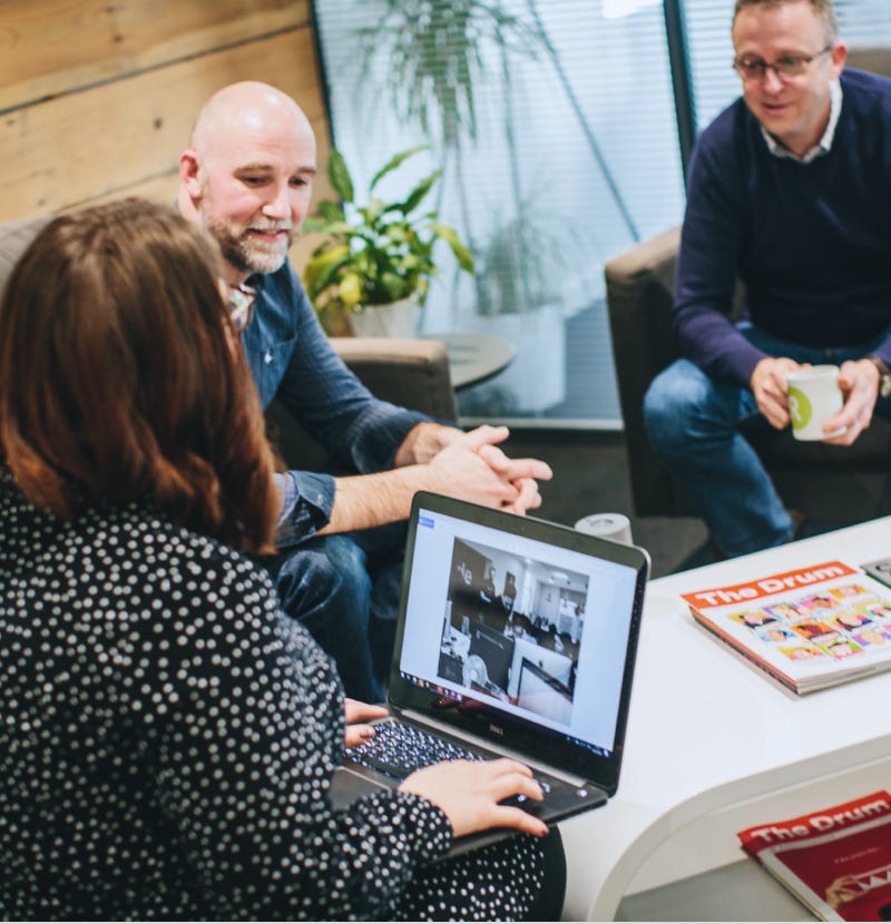 Ridgeway team members discussing a website over a coffee