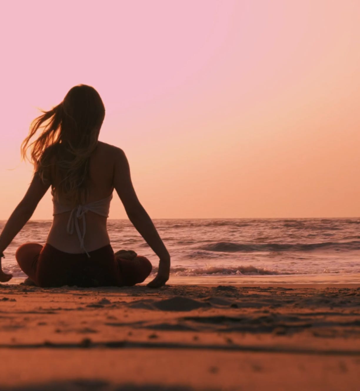 Lady practising yoga on the beach