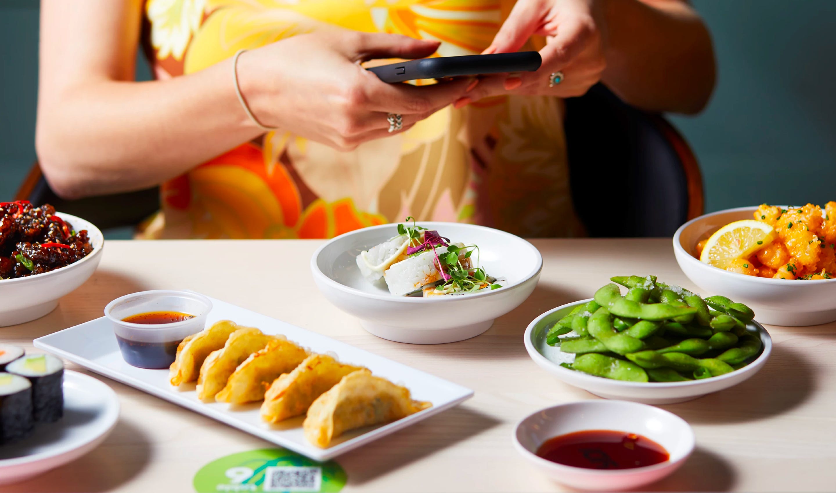 A lady taking a photo of her YO! sushi meal