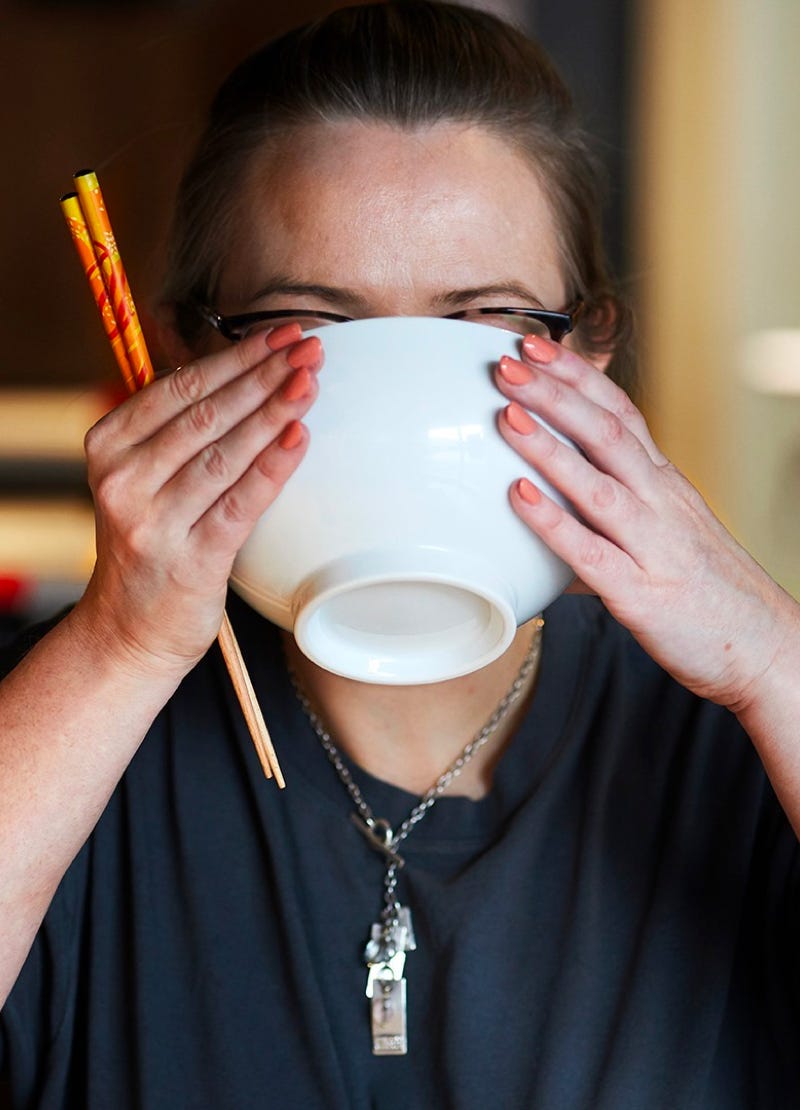 Woman eating noodles from a bowl