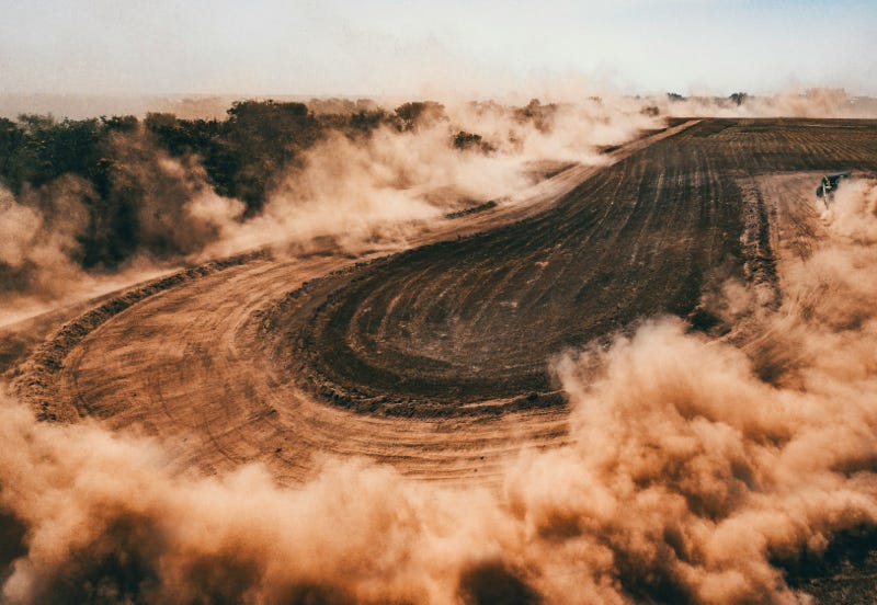 Dust cloud around a rally hairpin turn
