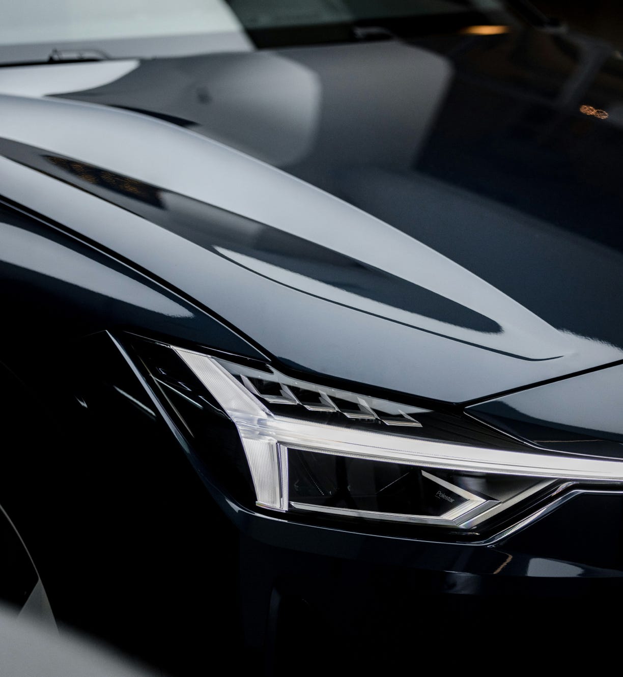 The front of a car focussing on the headlight and bumper