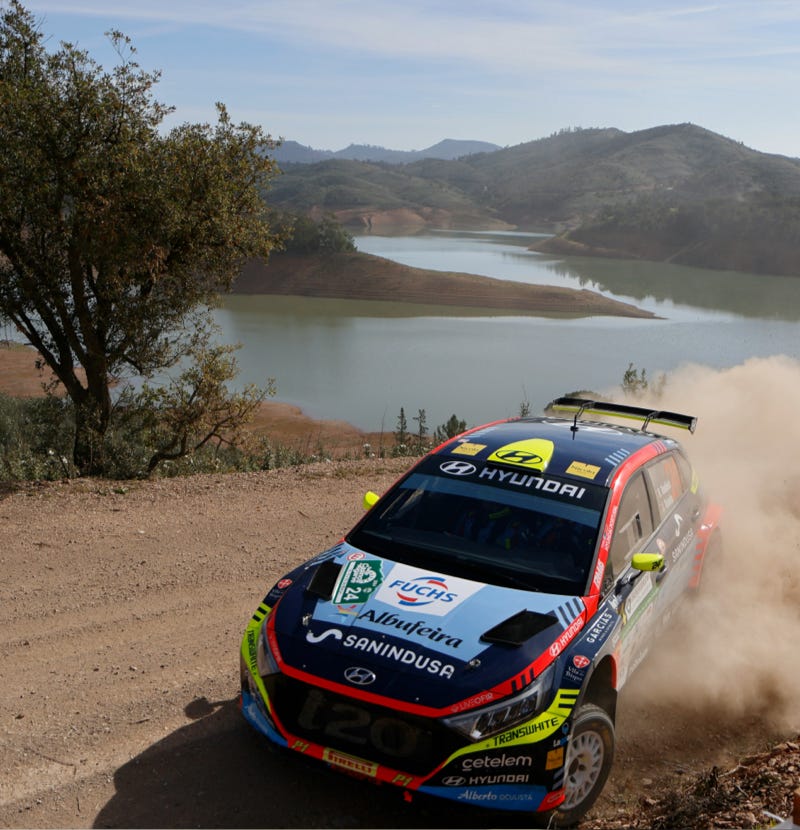 Rally car in front of lake on dirt track