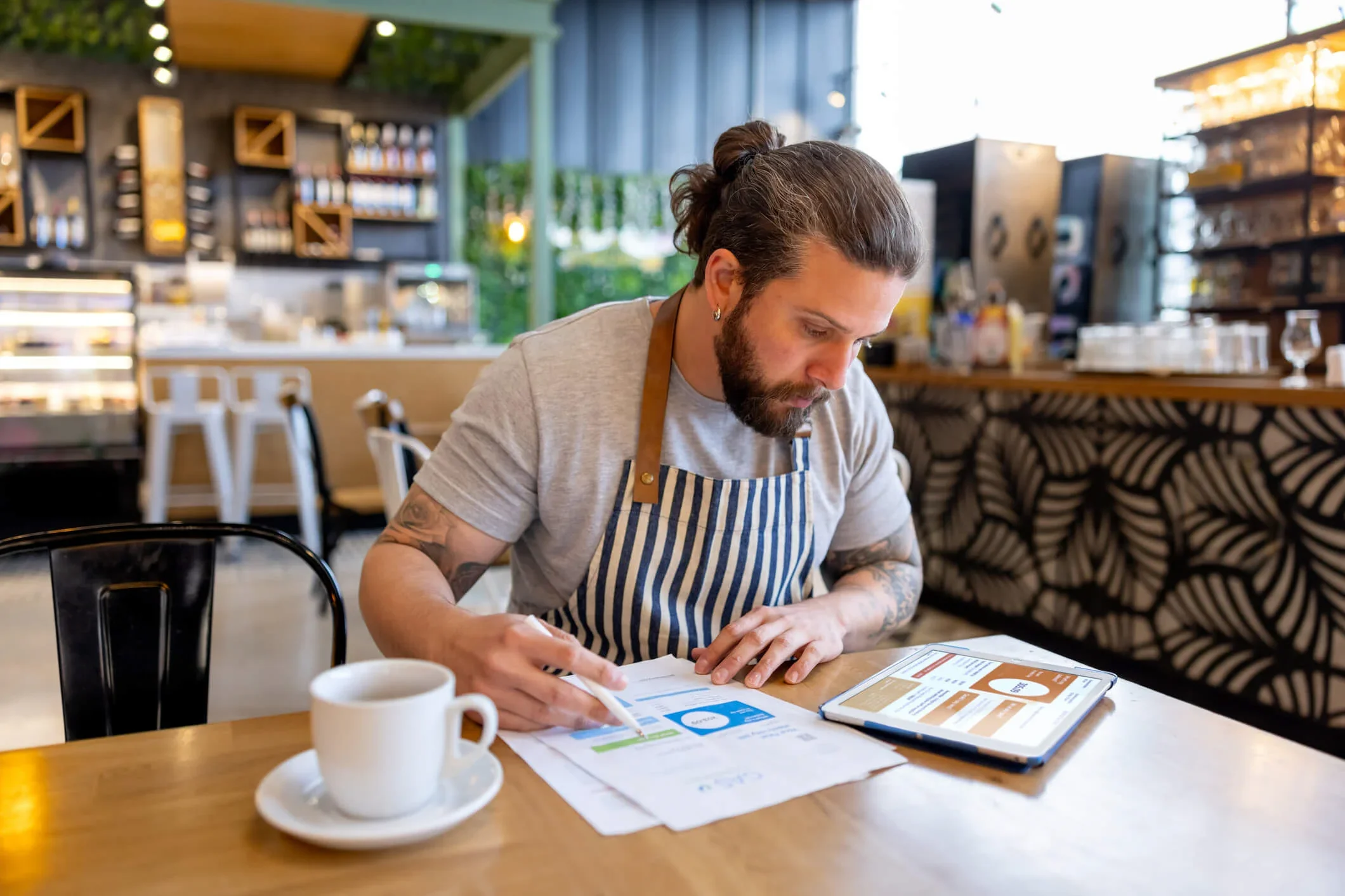 A business owner sits in his cafe and checks his energy bills for the RAB nuclear levy charge