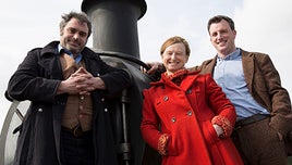 The presenters of Full Steam Ahead stood, smiling, in front of a steam train
