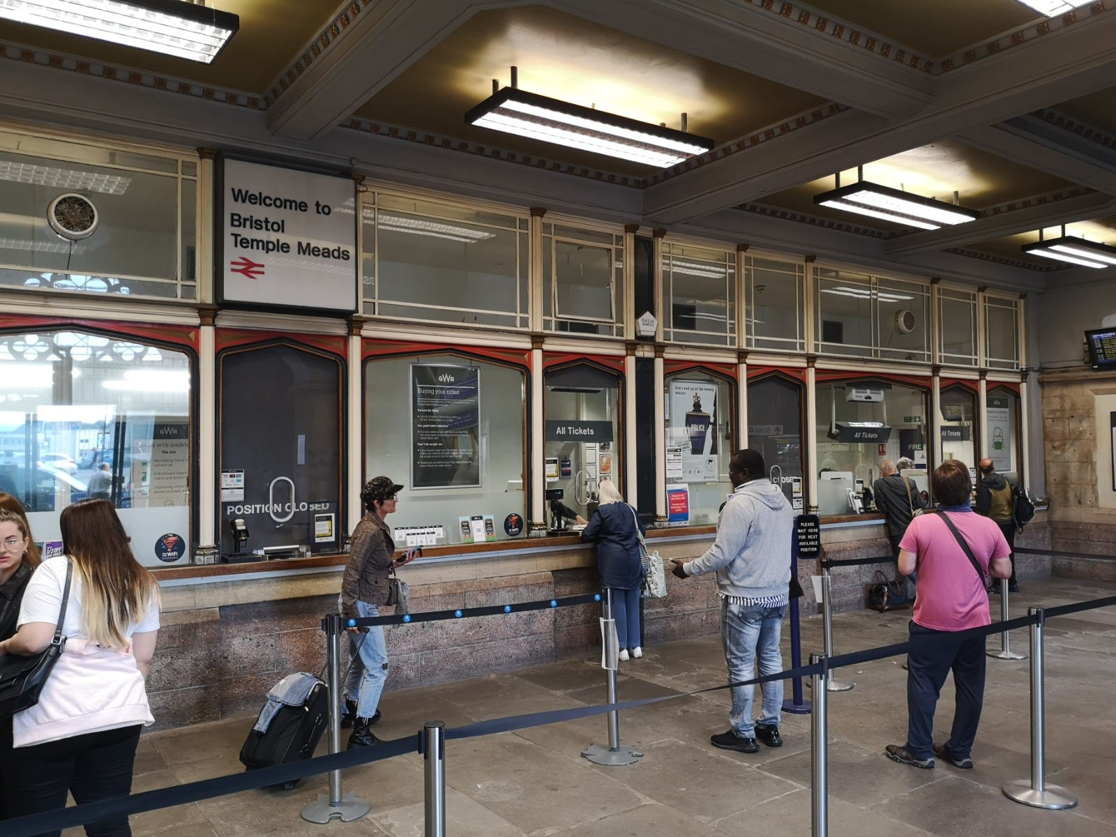 Bristol Temple Meads station ticket office. There are people waiting to be seen byt staff.