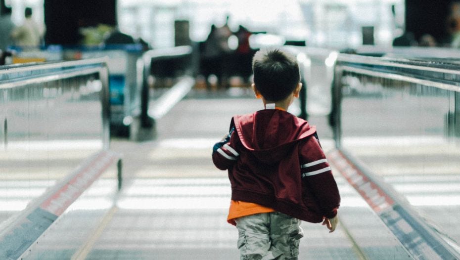 Boy running through station