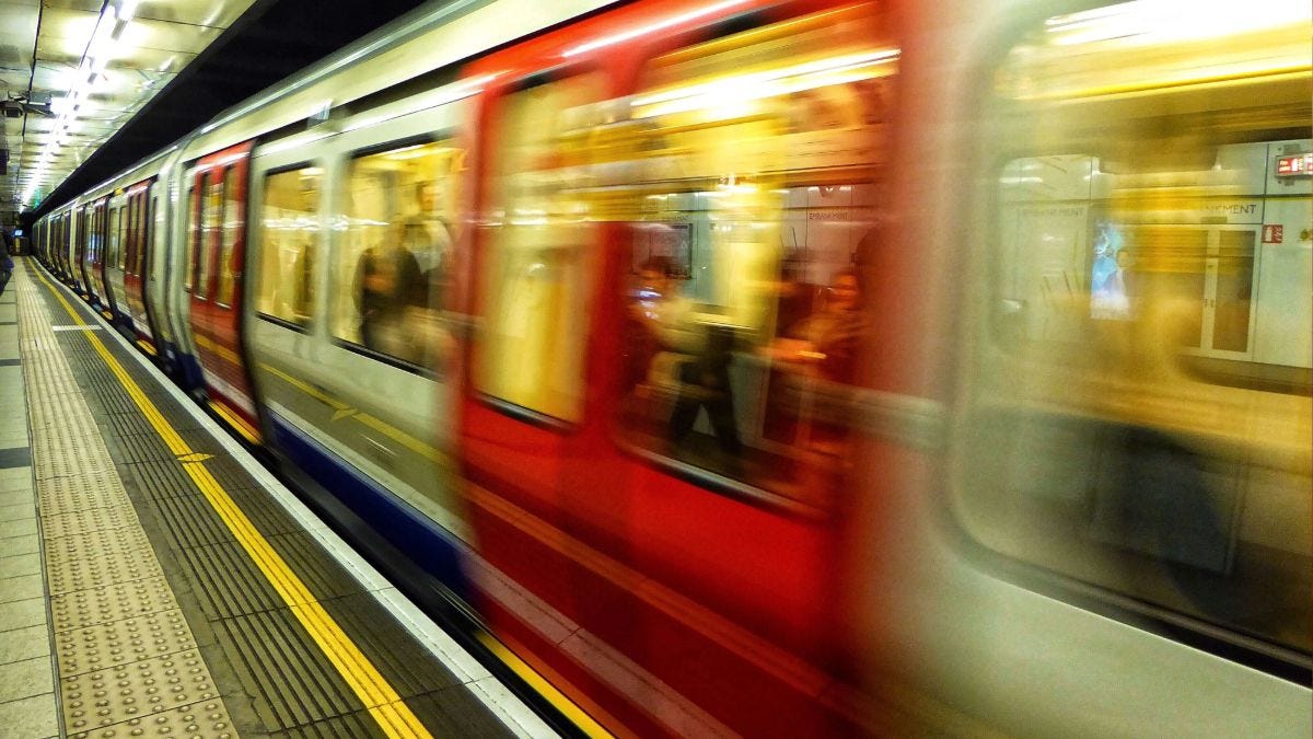 Tube train moving through underground station, TfL