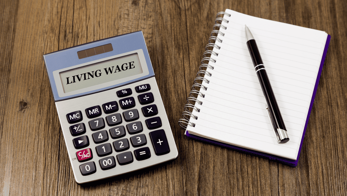 Photo of calculator displaying 'living wage' on screen and a pen and paper