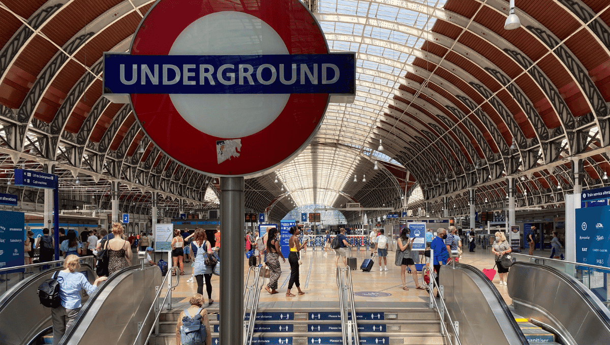 Underground sign in Paddington station in front of escalators and steps