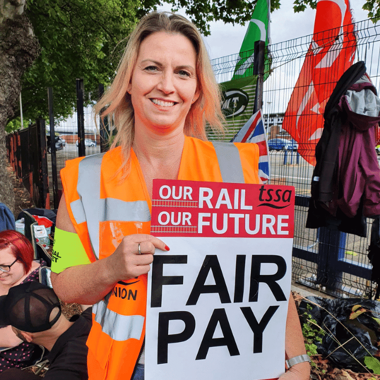 Photo of Louise holding a sign saying 'fair pay'