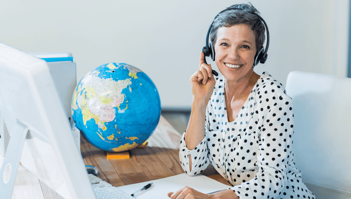 Travel trade picture showing a woman at laptop with globe on desk