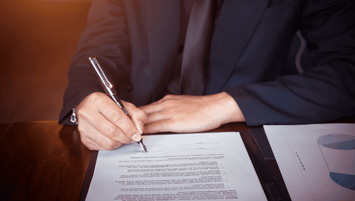 Man signing a document at a desk