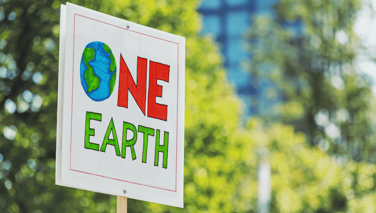 Climate change demo showing placard which reads: one earth