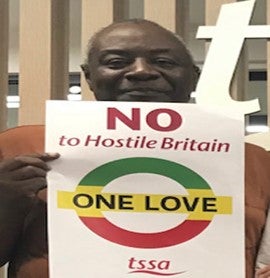 Wilf Sullivan, TUC Race Equalities Officer, holding poster saying No to Hostile Britain