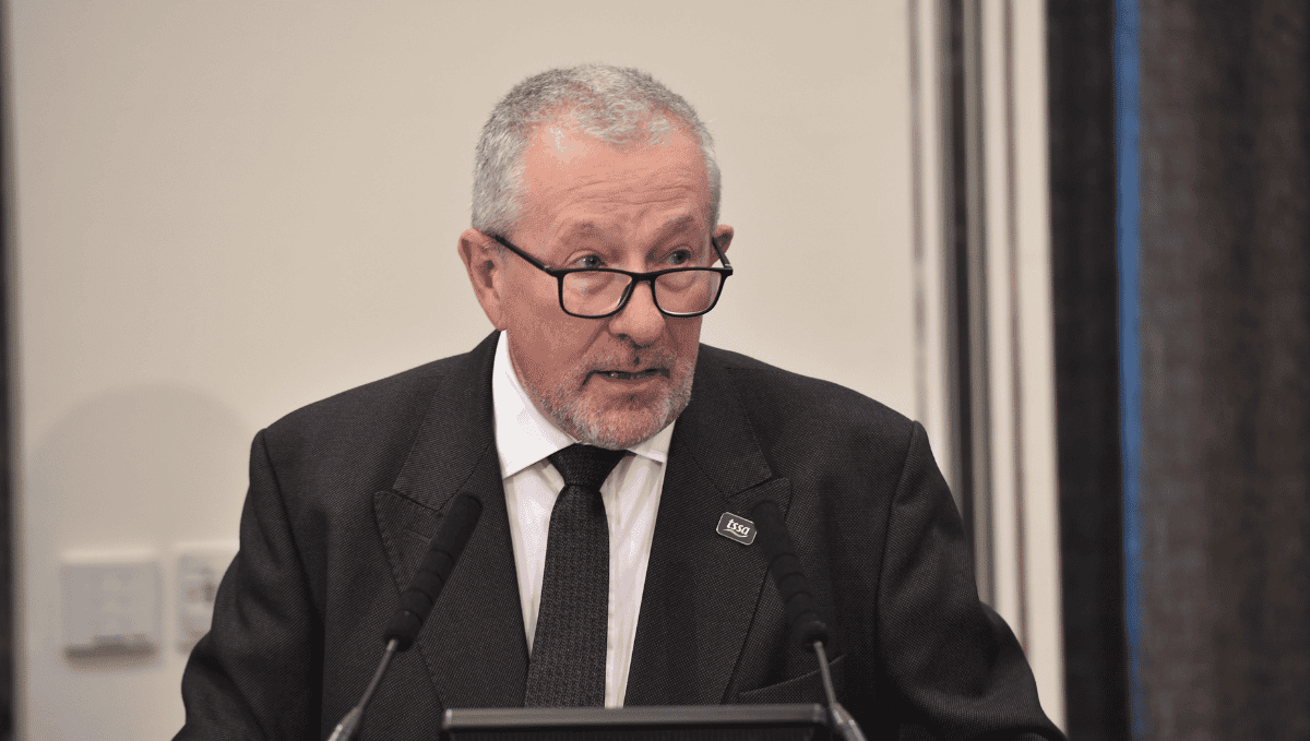 TSSA Interim General Secretary, Peter Pendle, addresses TSSA conference. A middle aged man is wearing a black suit with a black tie and a white shirt. He has glasses and grey hair and a beard.