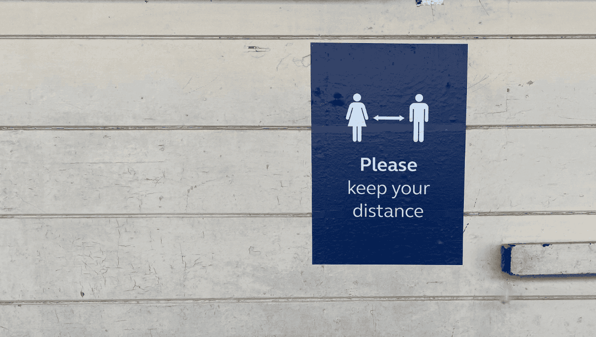 Social distancing poster at station which reads: Please keep your distance