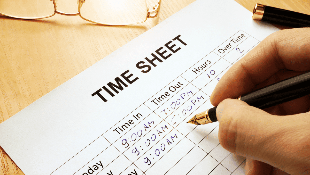 Photo of someone filling in a time sheet with a pen.