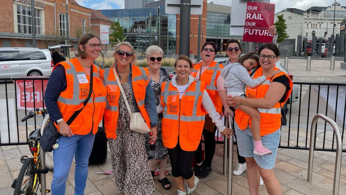 Group of women on picket picket line wearing orange high vis