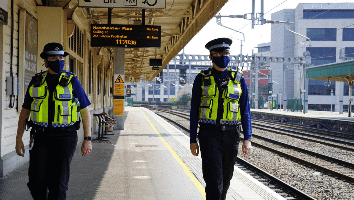 Two BTP officers wearing face masks on station platform