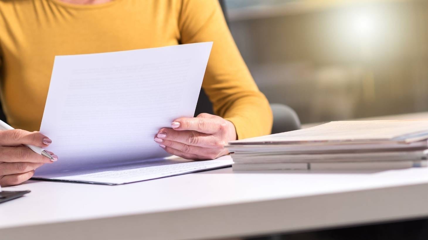 A female holding a piece of paper.