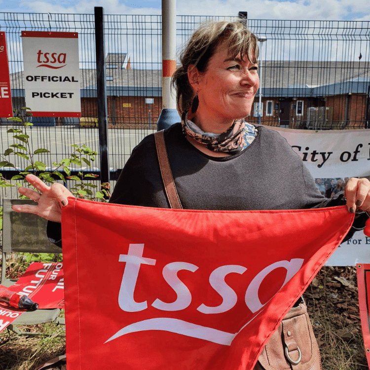 Dawn on picket line holding TSSA flag