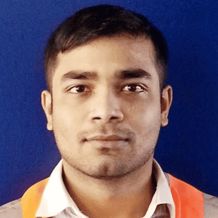 Tahmid Tonmoy, a young Asian man with a stubble and a chin dimple. He is wearing a grey shirt with a white collar and a yellow and orange scarf. He is looking at the camera.