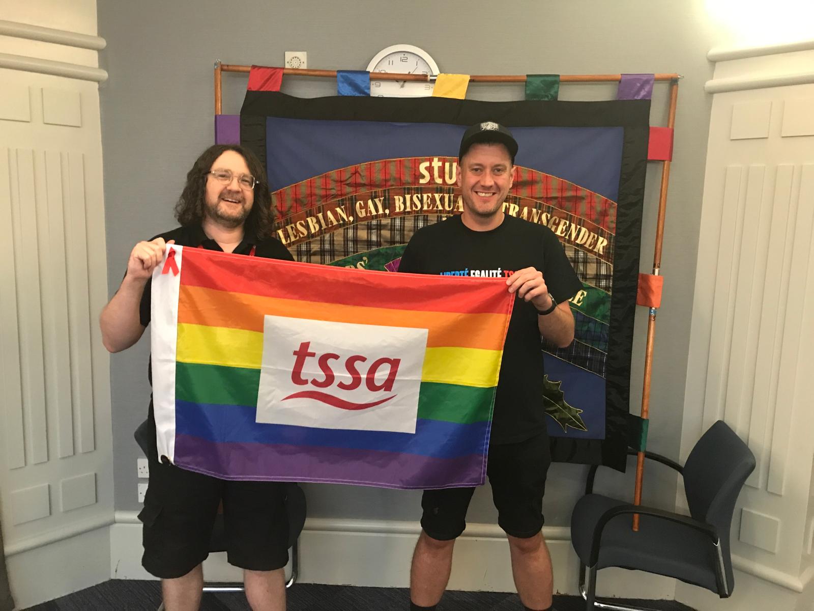 TSSA members Allan O'hare And Barry Weldon holding a Rainbow TSSA Flag the STUC LGBT+ Conference.