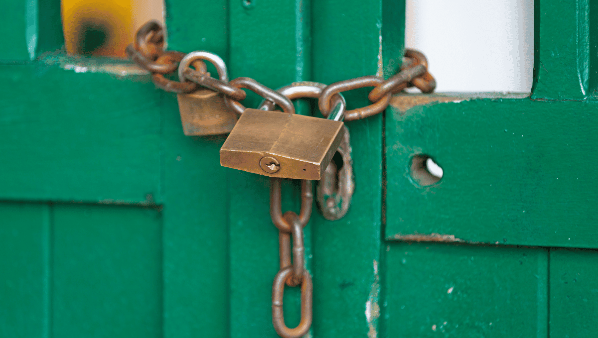 Padlock around closed door, shut up building