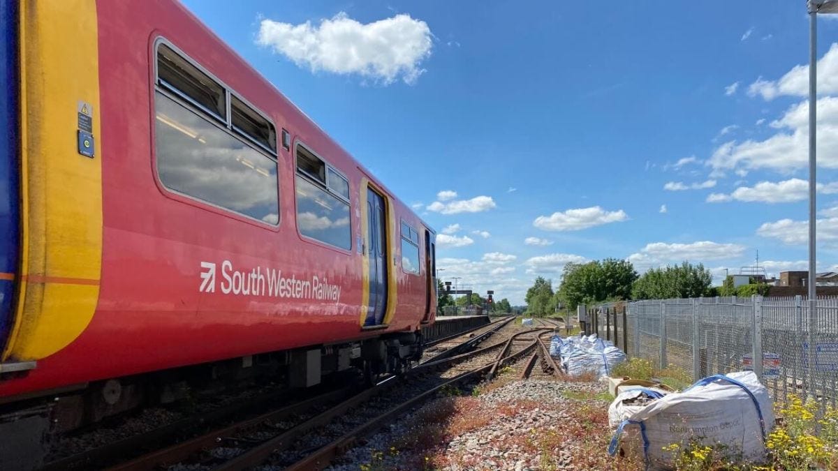 South Western Railway train on tracks at station