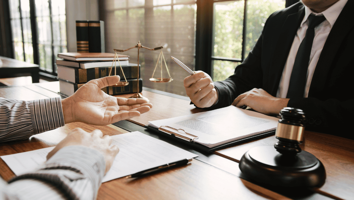 Lawyer and client discussion over a desk with documents. Photo By WIRUL KENGTHANKAN from Canva.