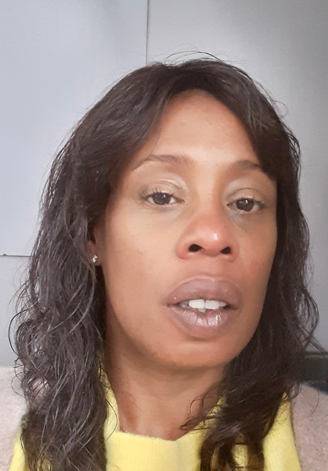 Image of Pamela, E-Mix Chair, a Black woman, with long black curly hair and wearing a yellow top.
