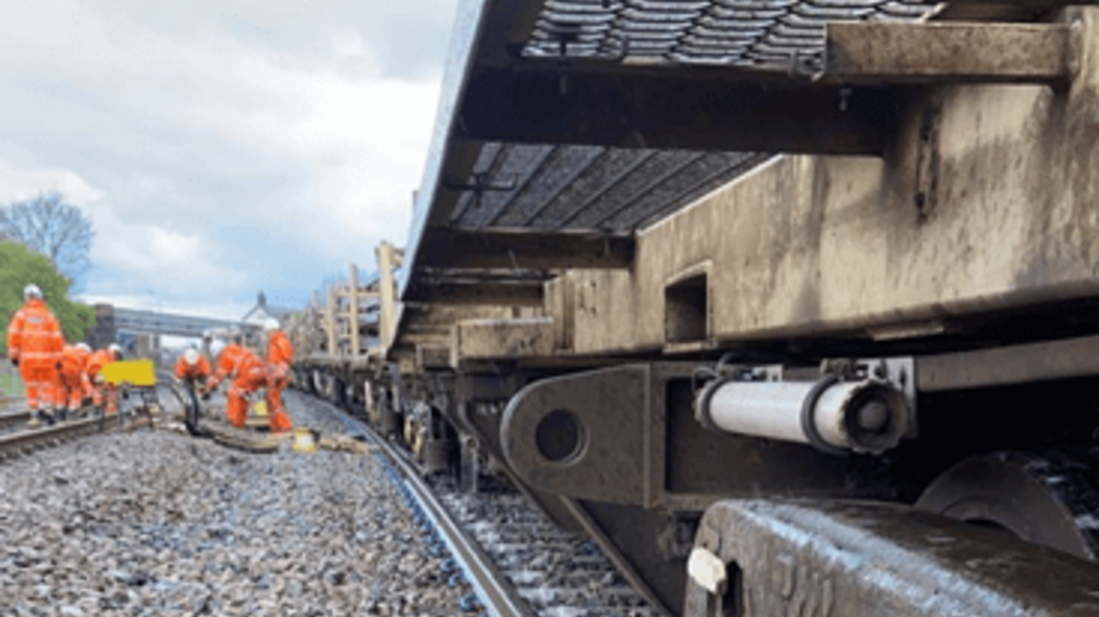 Network Rail team in orange high vis working on tracks at a derailment