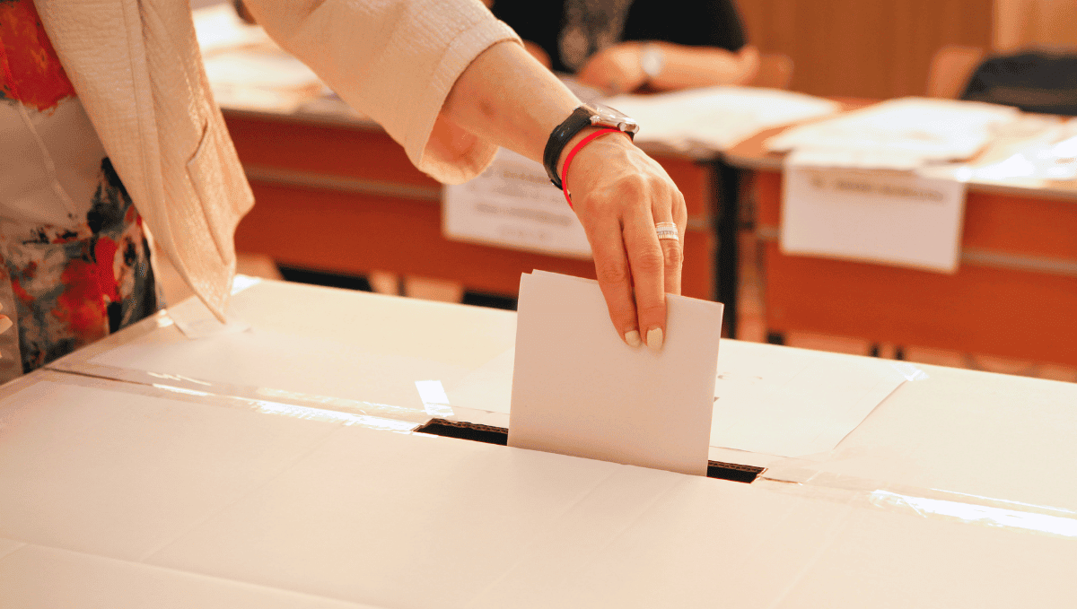 Woman placing voting card in ballot box