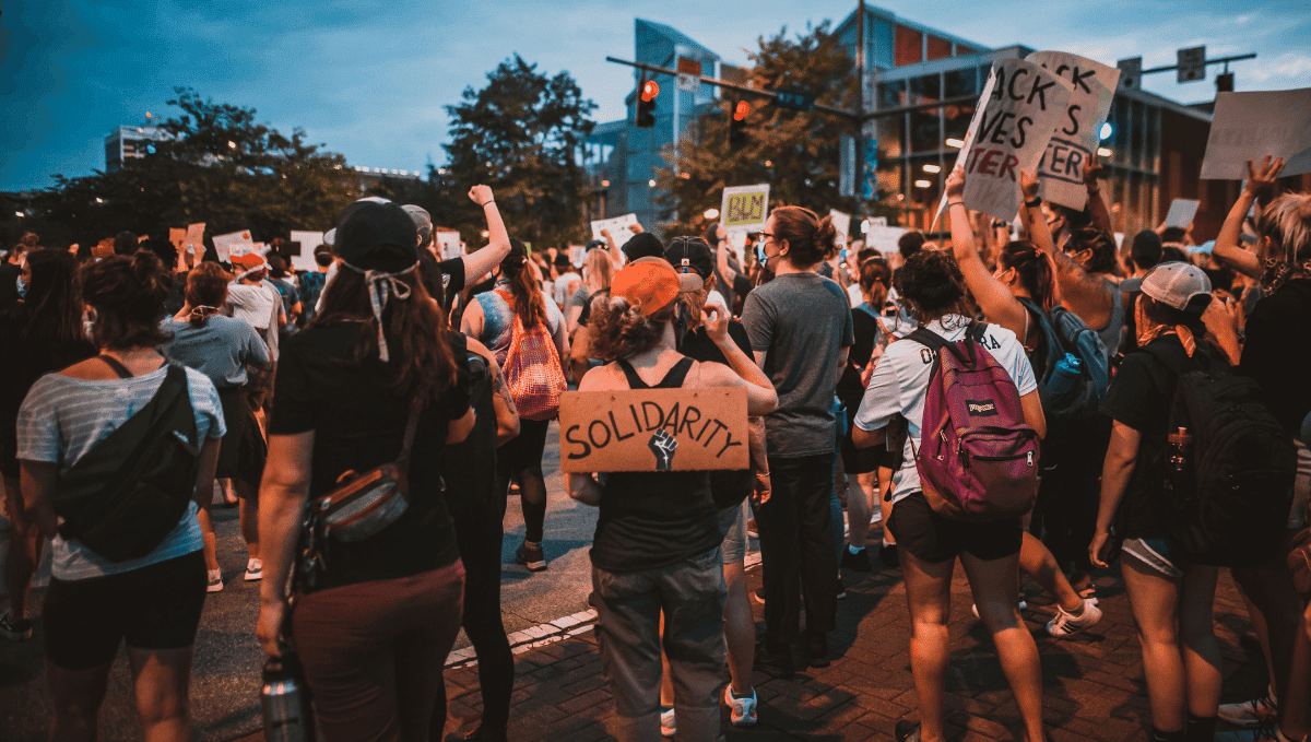 People at a demonstration with a sign saying 'solidarity'