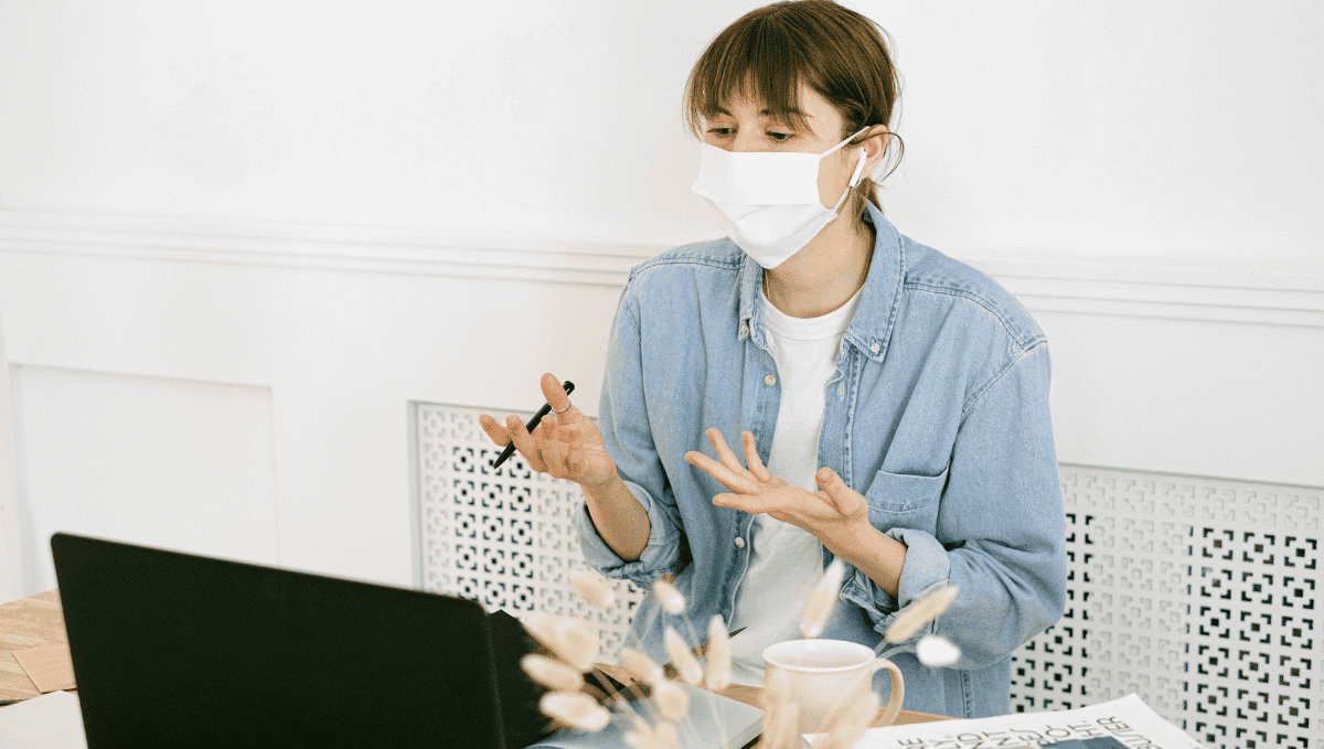 Young woman wearing face mask working with laptop