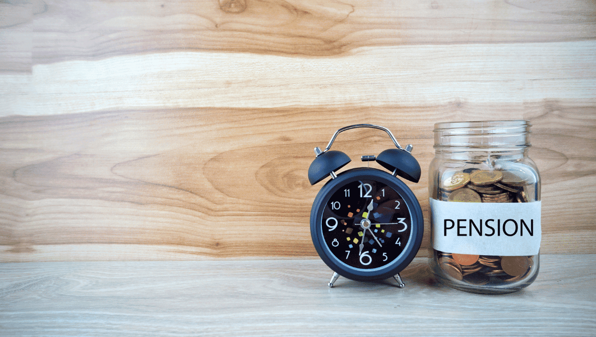 Alarm clock and money coins savings pot with 'pension' written on it