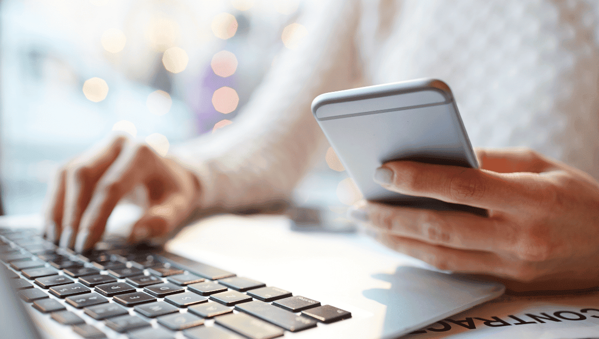 Woman working on laptop and phone