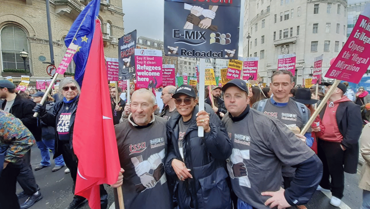 Peter Pendle, with other TSSA activists of varying ages and races wearing TSSA E-mix T-shirts, and holding TSSA flags.