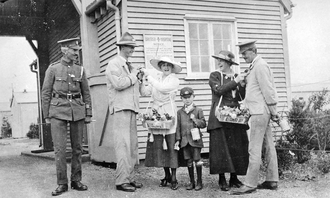 A group soldiers and civilians sell poppies to raise money for the Red Cross.